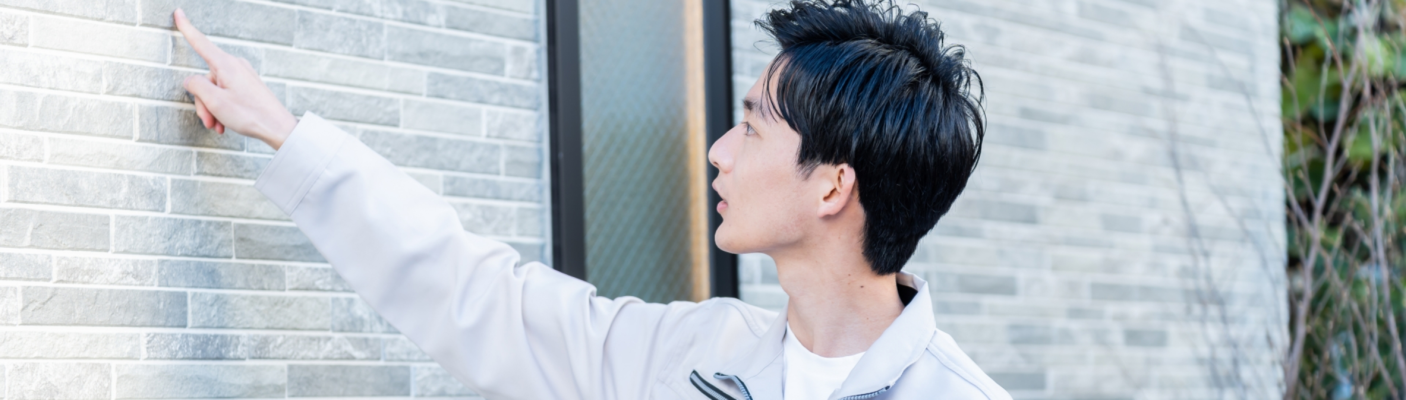 画像：男性社員が外壁の素材をチェックしている